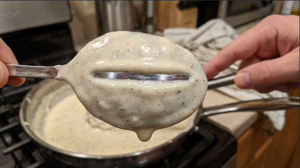Cream sauce coating the back of a spoon, thick enough to hold a line when you drag a finger through it