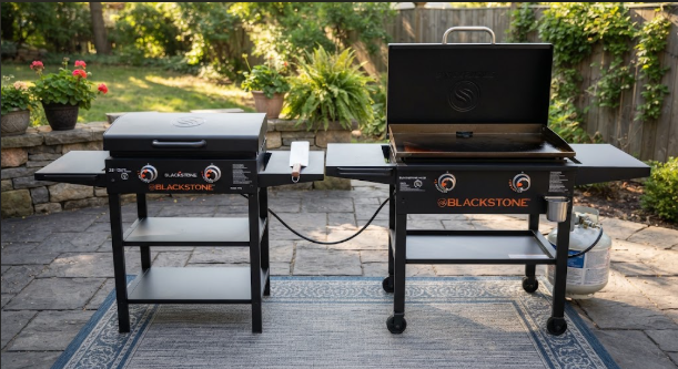 The 22-inch and 28-inch Blackstone side by side on a patio, with a tape measure or spatula for scale