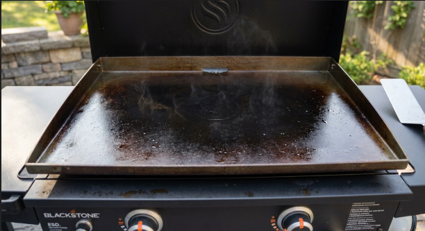 Seasoned Blackstone cooktop after a fresh oil coat, showing an even, dark, satin finish