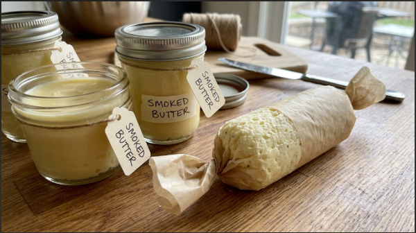 Finished jars of smoked butter next to a log of whipped smoked butter rolled in parchment paper