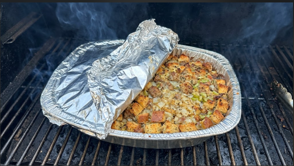  Stuffing in a foil pan on the smoker grate with the foil pulled back halfway through the cook