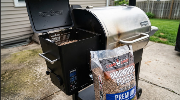 A Woodwind with the hopper lid open and a fresh 20 lb bag of pellets next to it