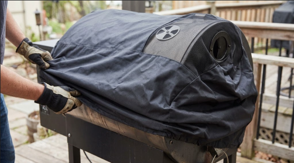 A cooled grill with the cover being pulled on, vents visible near the top