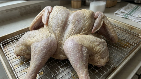 Turkey breast on a wire rack after dry brining, skin looking dry and tight