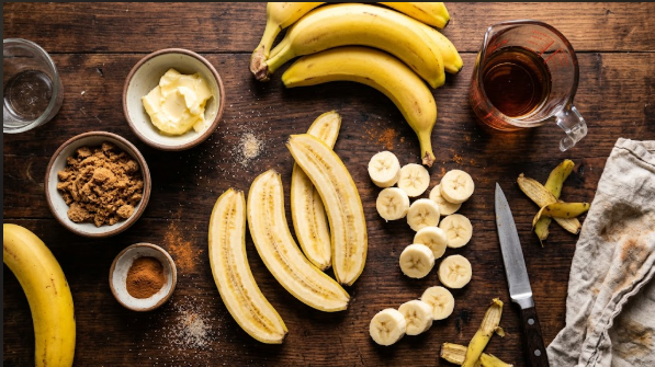 Bananas sliced lengthwise and crosswise, with butter, brown sugar, cinnamon, and a measured cup of rum laid out in small bowls