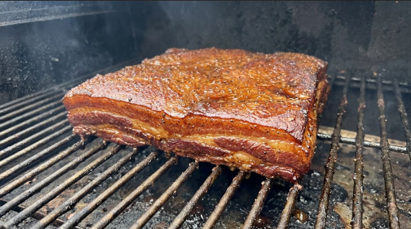  Pork belly on the smoker grate after 3 hours, with dark mahogany bark forming