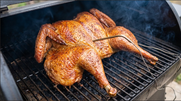Spatchcocked turkey on the smoker grate with a probe in the breast