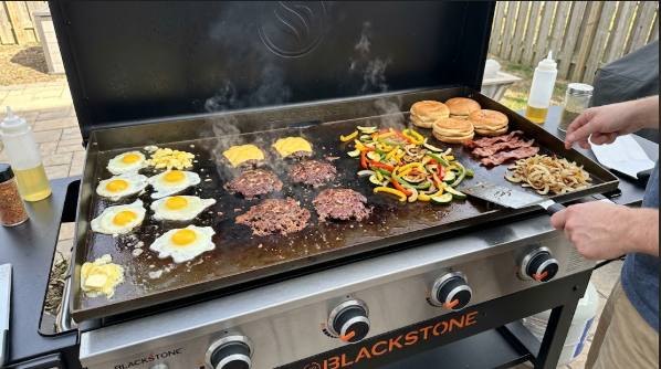 36 inch Blackstone with four zones in use: eggs, burgers, vegetables, and a cool zone