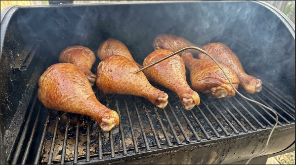Legs on the smoker grate at the 2-hour mark with a probe in the thickest part