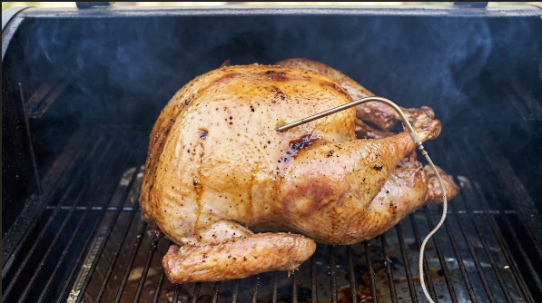  Injected turkey on the smoker with probe in the breast, skin starting to turn golden
