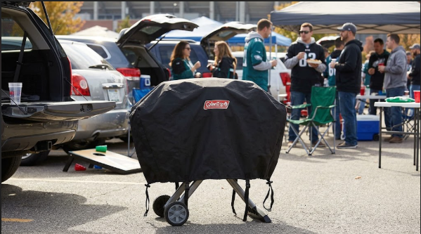 RoadTrip grill with its cover strapped on at a tailgate
