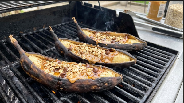 Grilled banana boats opened on the grate with melted nut butter and oats