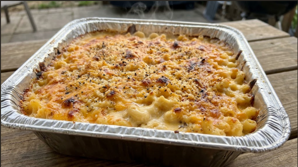 Smoked mac and cheese in a foil pan, golden on top, steam rising