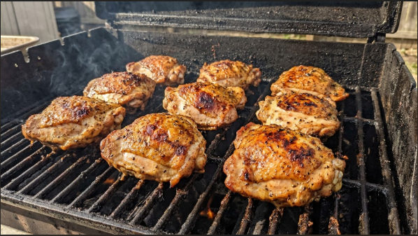 Smoked chicken thighs on the grate with crisp, golden-brown skin