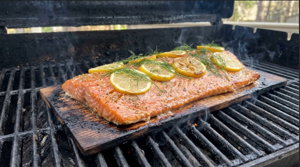 Salmon fillet on a cedar plank with lemon slices and dill