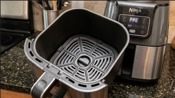 An empty Ninja air fryer basket with the crisper plate in place, ready to preheat