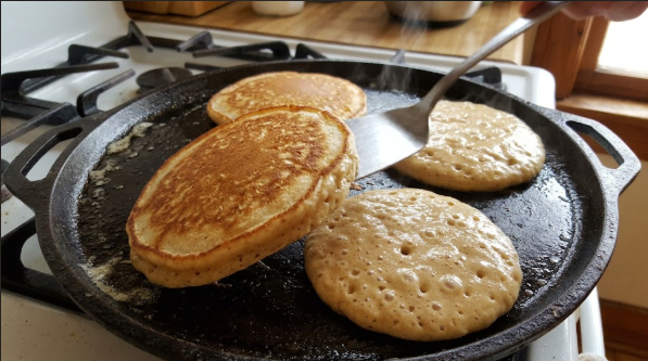 One pancake being flipped, showing the golden brown first side