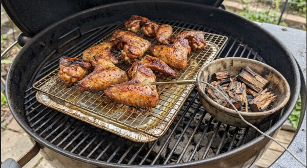 Finished smoked wings on a wire rack with golden, blistered skin