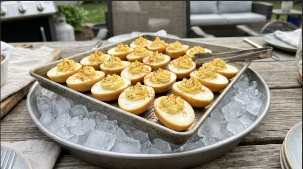 Smoked deviled eggs piped and arranged on a tray set over ice