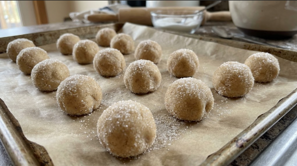 Dough balls rolled in sugar, lined up on parchment before pressing