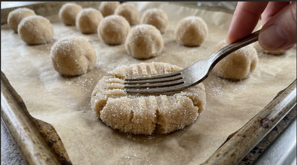 Fork crisscross pressed into a dough ball, showing the pattern and thickness