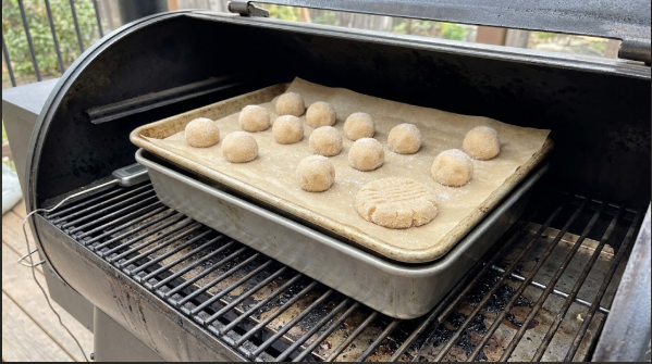 Cookie sheet on a pellet grill grate with a second pan stacked underneath