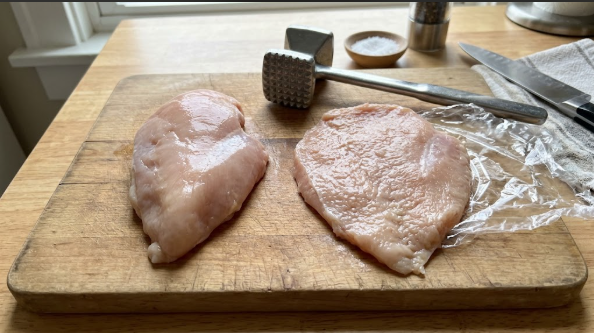 Chicken breast pounded to even ¾-inch thickness on a cutting board, next to an unpounded breast for comparison
