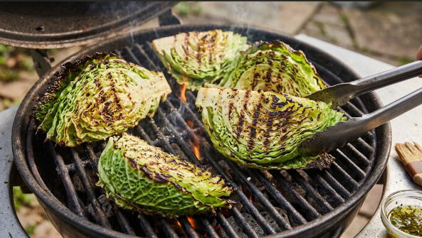 Charred cabbage wedges on a grill with visible grill marks